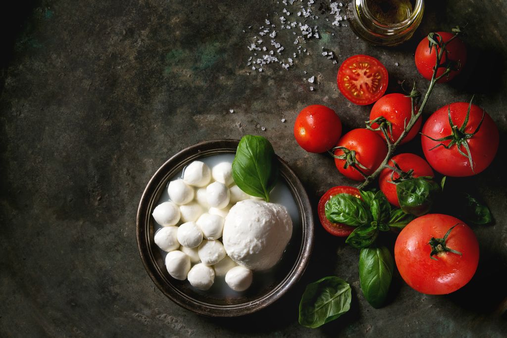 mozzarella balls on a plate with basil and tomatoes