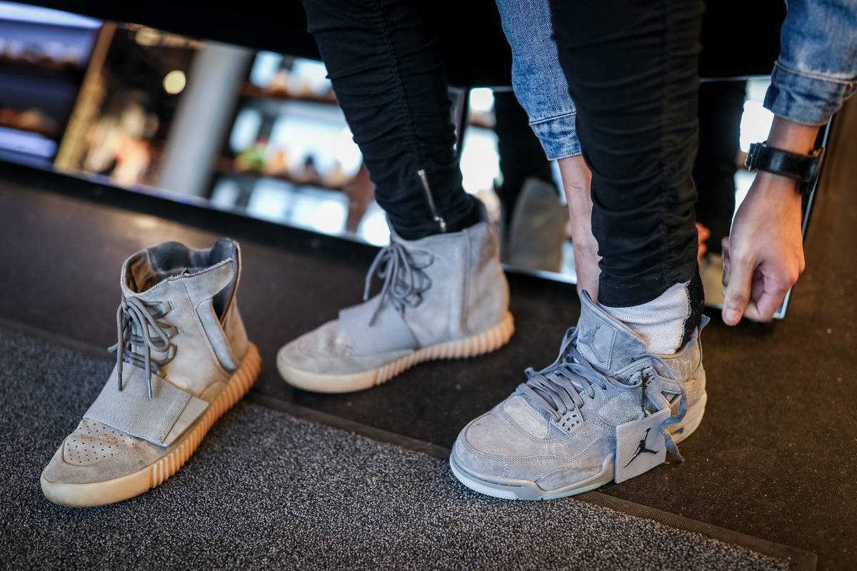 A man tries on sneakers at a store.